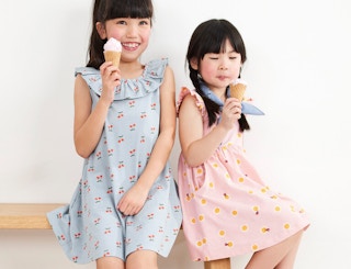 two girls eating ice cream in dresses