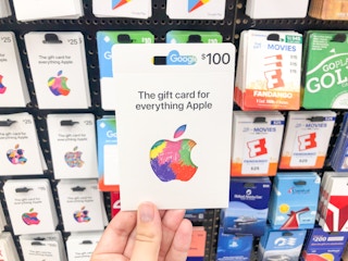 hand holding Apple gift card in front of gift card display at Target