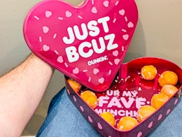 z person holding the heart shaped Dunkin donuts box on lap