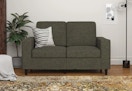 gray loveseat with a pillow on it