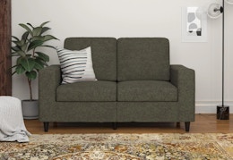 gray loveseat with a pillow on it