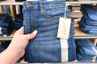 hand holding a pair of universal thread jeans at target