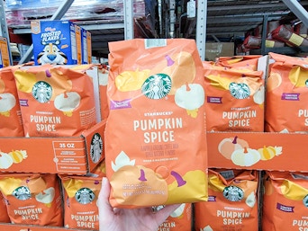 hand holding a bag of starbucks pumpkin spice coffee