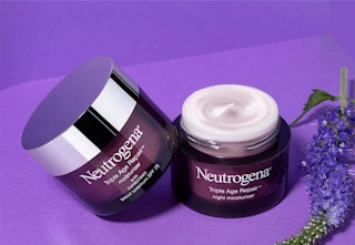 two purple jars with face cream on a purple surface