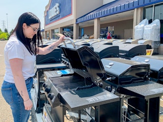 a person looking at grills at lowe's