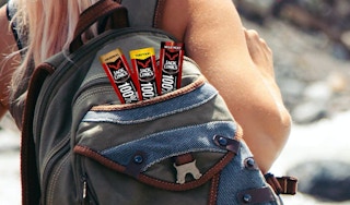 A woman carrying three beef links in a backpack