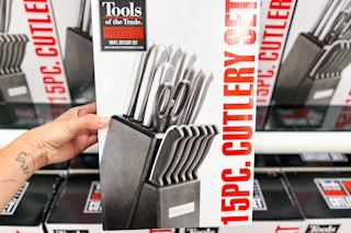 someone holding up a 15 piece knife set in a box 