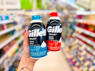 hand holding 2 gillette foamy shave cream in a store aisle