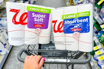 person pushing a cart with toilet paper and paper towels in it
