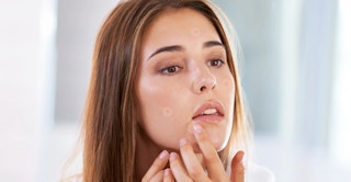 a person putting on pimple patches
