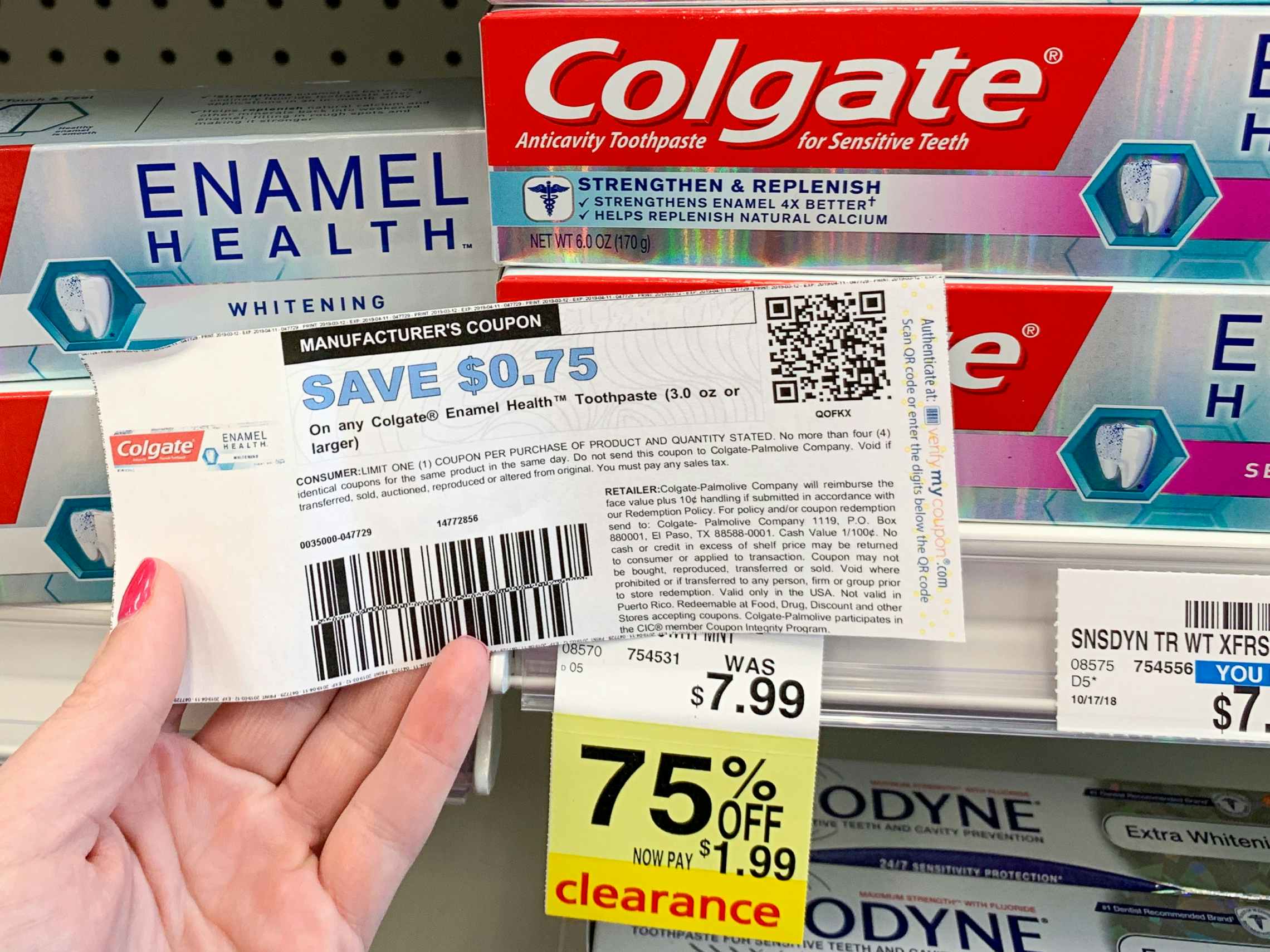 person holding a manufacturers coupon for colgate toothpaste in cvs