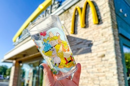 someone holding a collector cup outside of mcdonalds