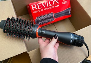 hand holding a revlon one step volumizer plus over a box