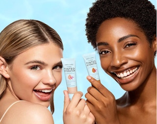 Two women holding foundation bottles