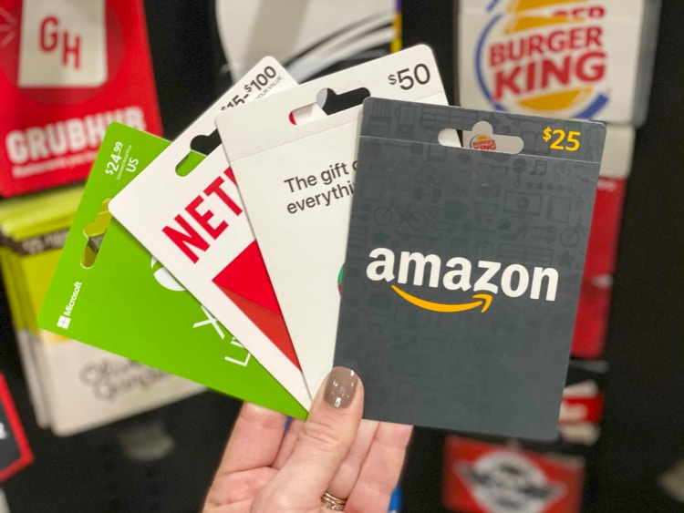 Hand holding Xbox, Netflix, Apple, Amazon gift cards