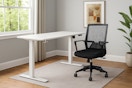 lifestyle image of a white standing desk with black desk chair