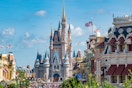 Disneyworld park and castle filled with people.