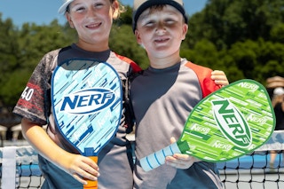 kids at a pickleball court with nerf paddles