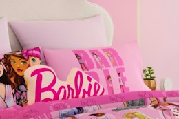 a barbie throw pillow on a bed