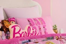a barbie throw pillow on a bed