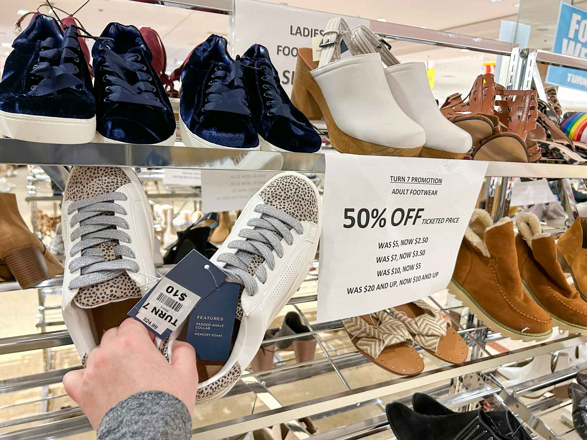 Sneakers marked $10 next to a sign saying they are 50% off