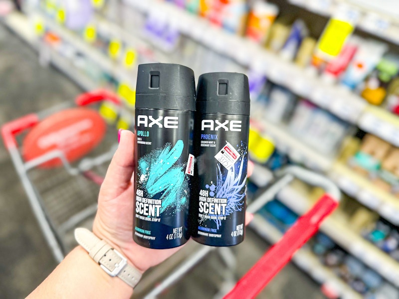 person holding 2 axe body sprays over a cart
