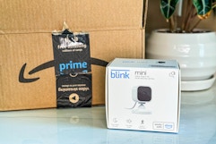 a Blink Mini in a box next to an Amazon box