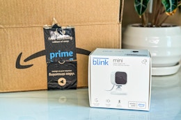 a Blink Mini in a box next to an Amazon box