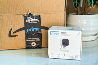 a Blink Mini in a box next to an Amazon box