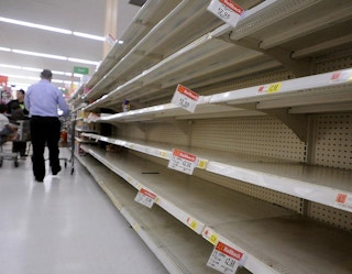 Empty shelves in a grocery store aisle.
