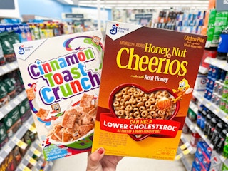 hand holding two general mill cereals