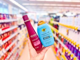 hand holding ogx and nexxus shampoos in walgreens