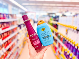 hand holding ogx and nexxus shampoos in walgreens