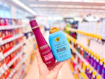 hand holding ogx and nexxus shampoos in walgreens