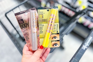 hand holding two maybelline mascaras