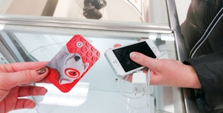 A woman exchanging her old iphone for a target gift card through the target trade-in program in store
