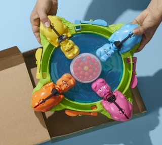 a hand pulling the Hungry Hungry Hippos Game out the box