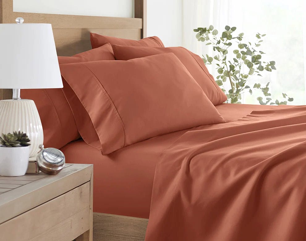 a clay-colored sheet set on a bed