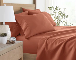 a clay-colored sheet set on a bed