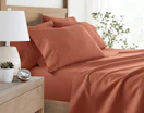 a clay-colored sheet set on a bed