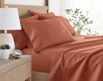 a clay-colored sheet set on a bed