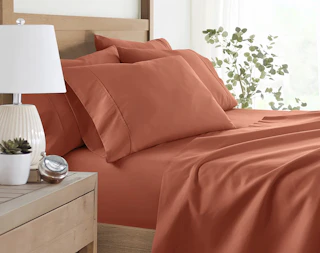 a clay-colored sheet set on a bed