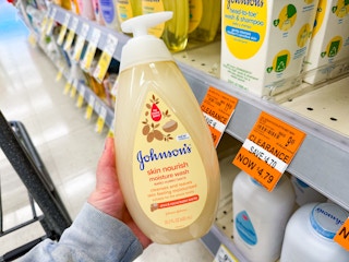 person holding a bottle of johnsons baby wash by a $4.79 clearance sign