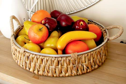 Lifestyle image of a DecMode Wicker Table Tray with fruit inside