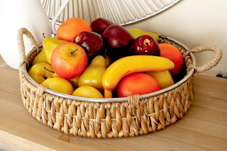 Lifestyle image of a DecMode Wicker Table Tray with fruit inside