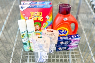 lucky charms cereal, tide detergent, crest toothpaste, venus razors, and batiste dry shampoo in a cart