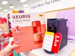 hand holding a keurig mate if front of a target shelf