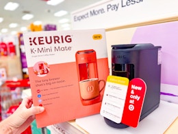 hand holding a keurig mate if front of a target shelf