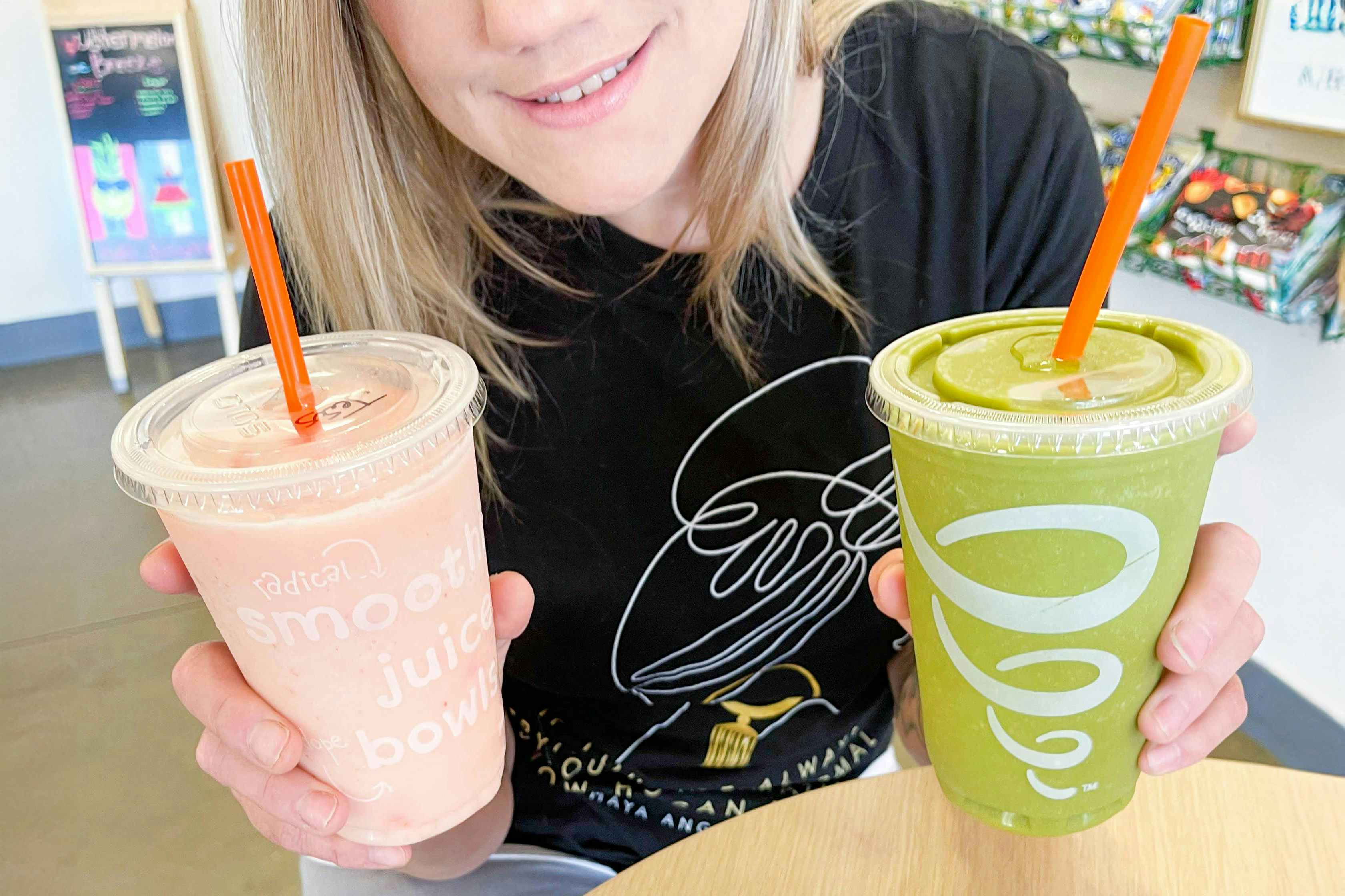 a person holding a smoothie in each hand.