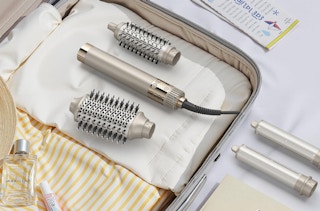 a hair styler in a suitcase with clothes and accessories